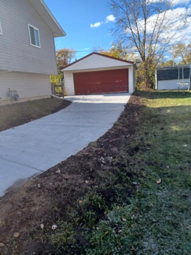 After: smooth new concrete driveway with clean edges and proper drainage, poured by Creative Concrete Company